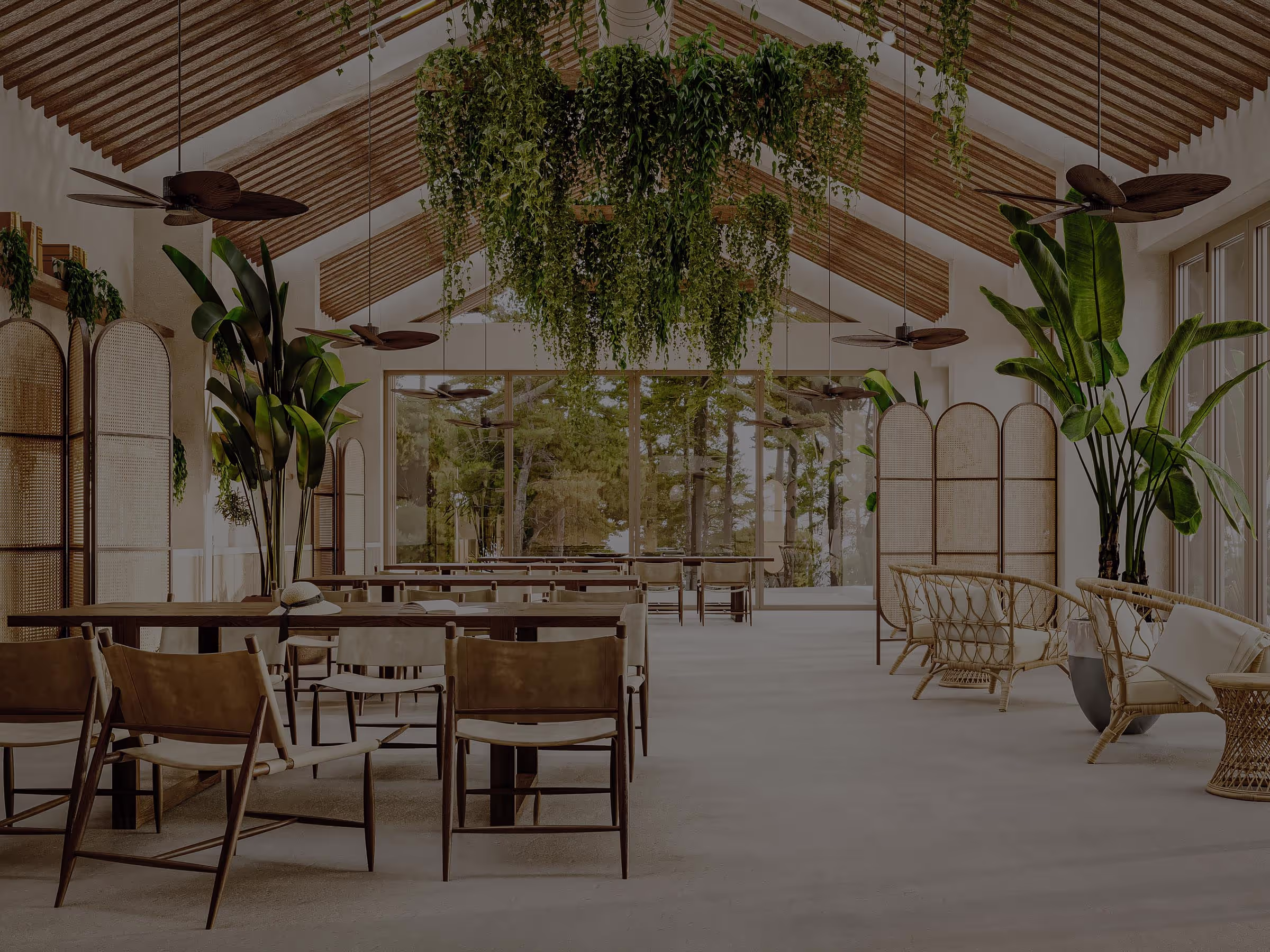Luxurious indoor swimming pool with a wooden ceiling and beams, surrounded by lush green plants. Sun loungers line the sides, and large windows at the end offer a view of greenery outside.