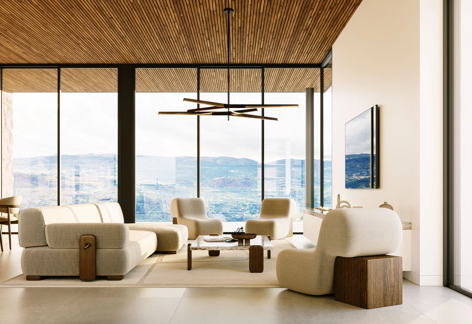 The living room: pale seating on a stone floor, a timber-slatted ceiling running the depth of the room, a sculptural black pendant, and glazing on two sides opening to the valley.