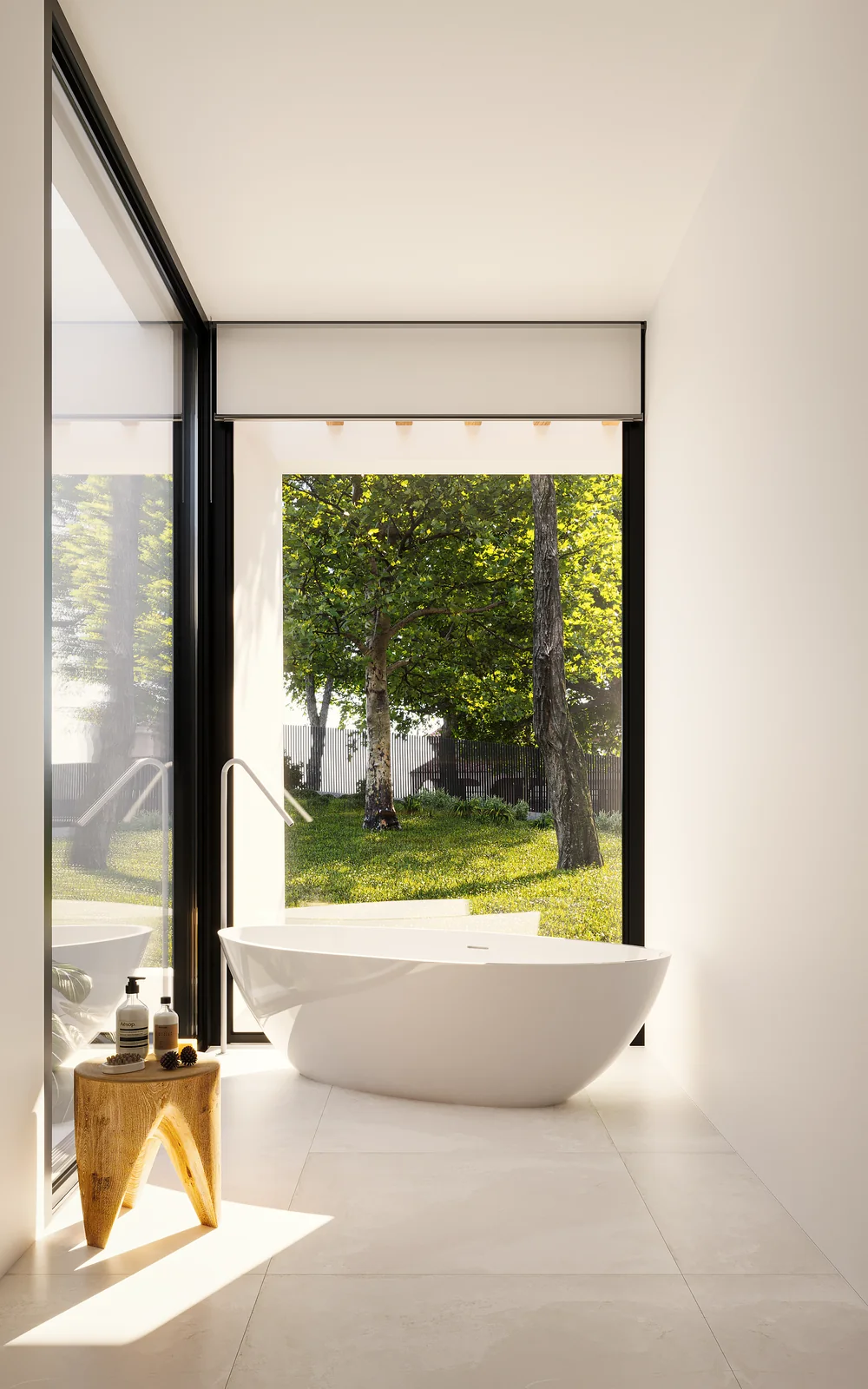 A bathroom with a freestanding bath in front of a full-height opening onto trees.