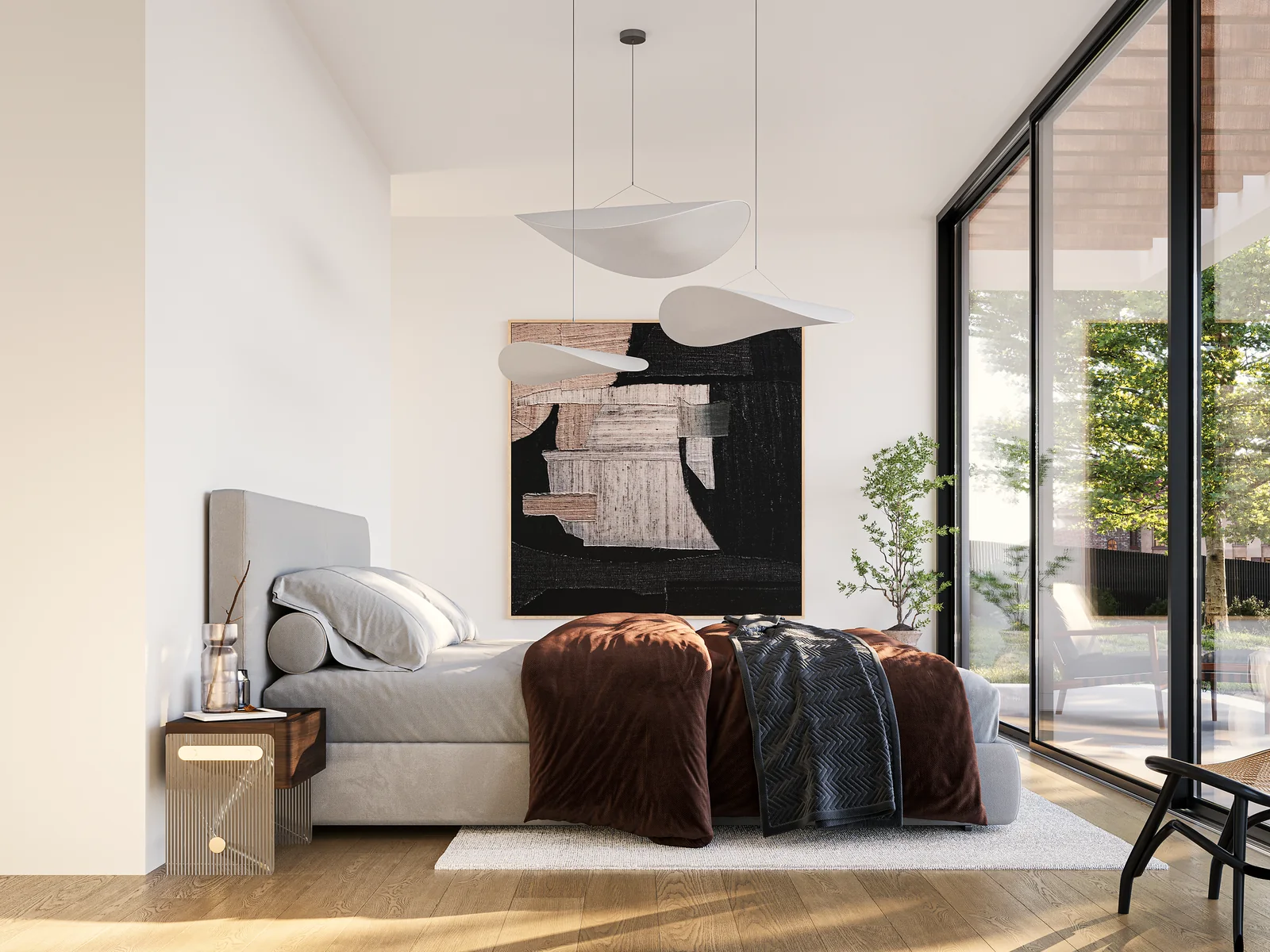 A bedroom with a low bed, artwork above it and a glazed wall onto the terrace.