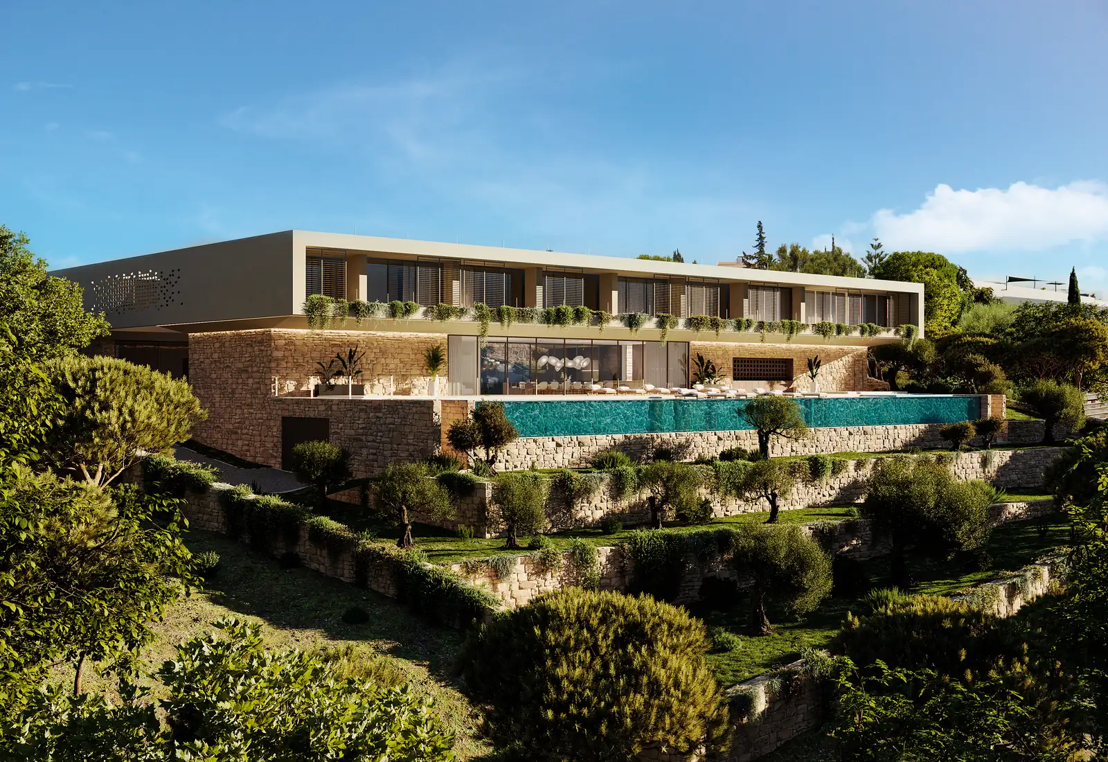 The house seen from across the valley: dry-stone terraces stepping up the slope, the pool inserted into them, and a single low horizontal volume with a green roof sitting on top, pine and scrub all around.
