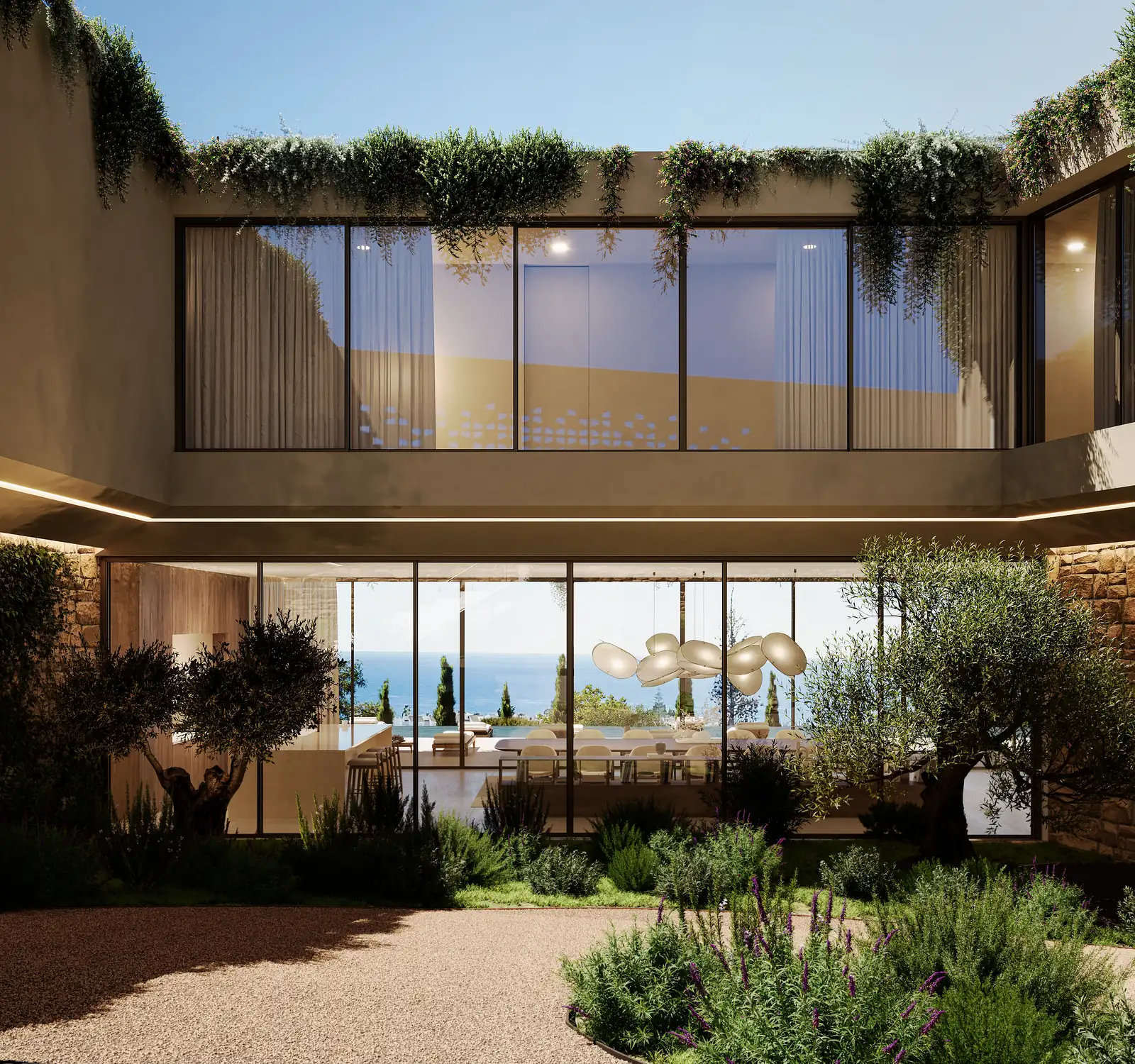 An entrance courtyard cut into the volume, walls lined in vertical timber, a planted parapet overhanging above, and the sea visible through the house on the far side.