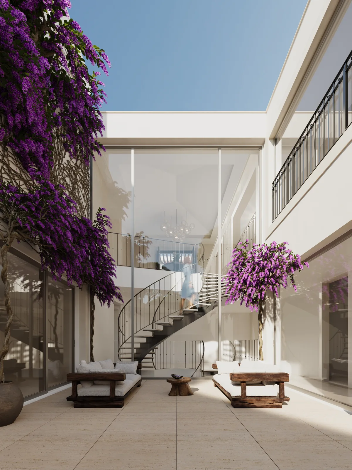 A narrow courtyard cut down between two white walls, a spiral stair in white metal descending into it, bougainvillea spilling over the parapet above and full-height glazing on both sides.