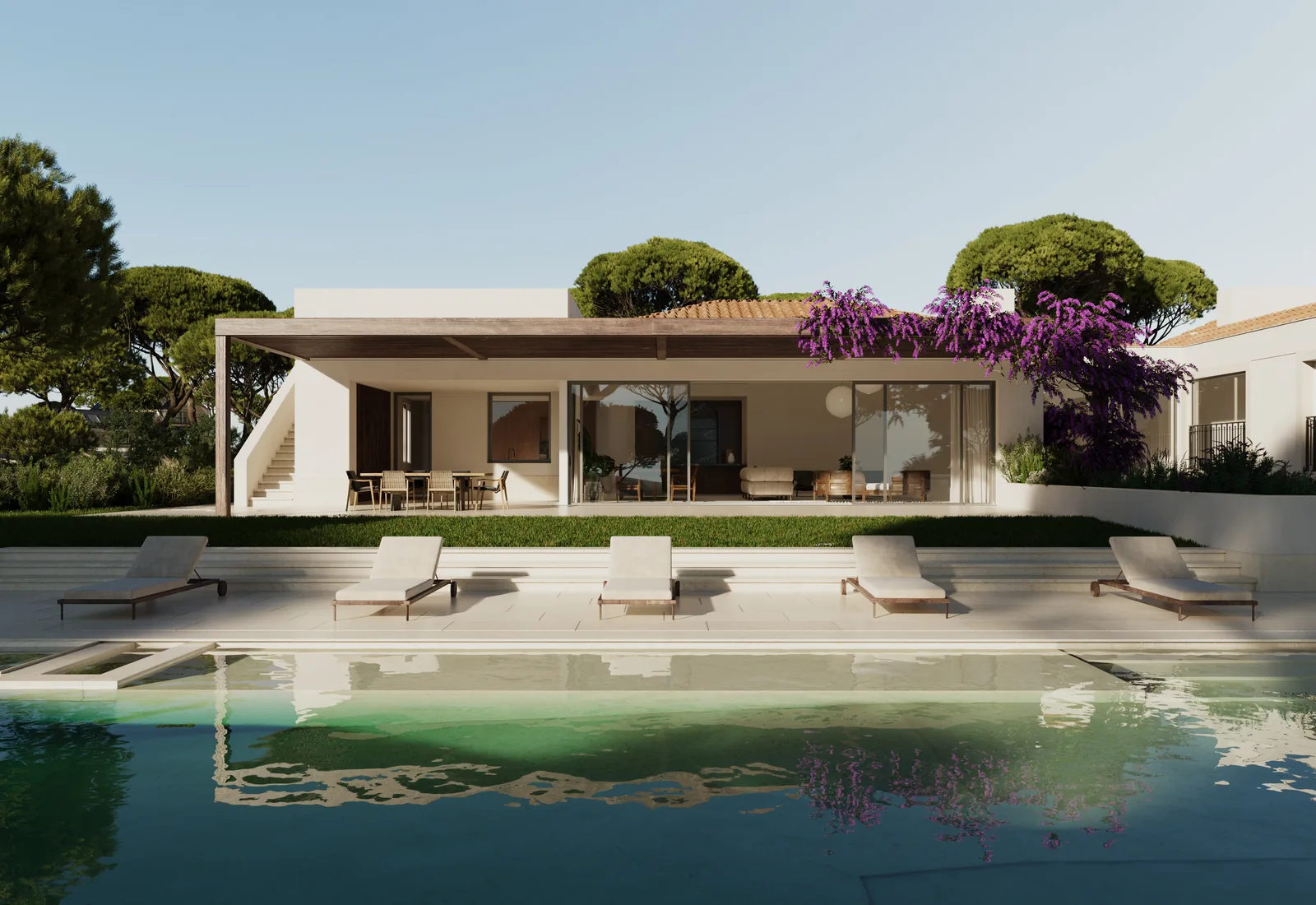 A long pool in front of a low white house: the whole living side opens under a deep loggia, loungers along the stone deck, umbrella pines behind and bougainvillea over the end wall.