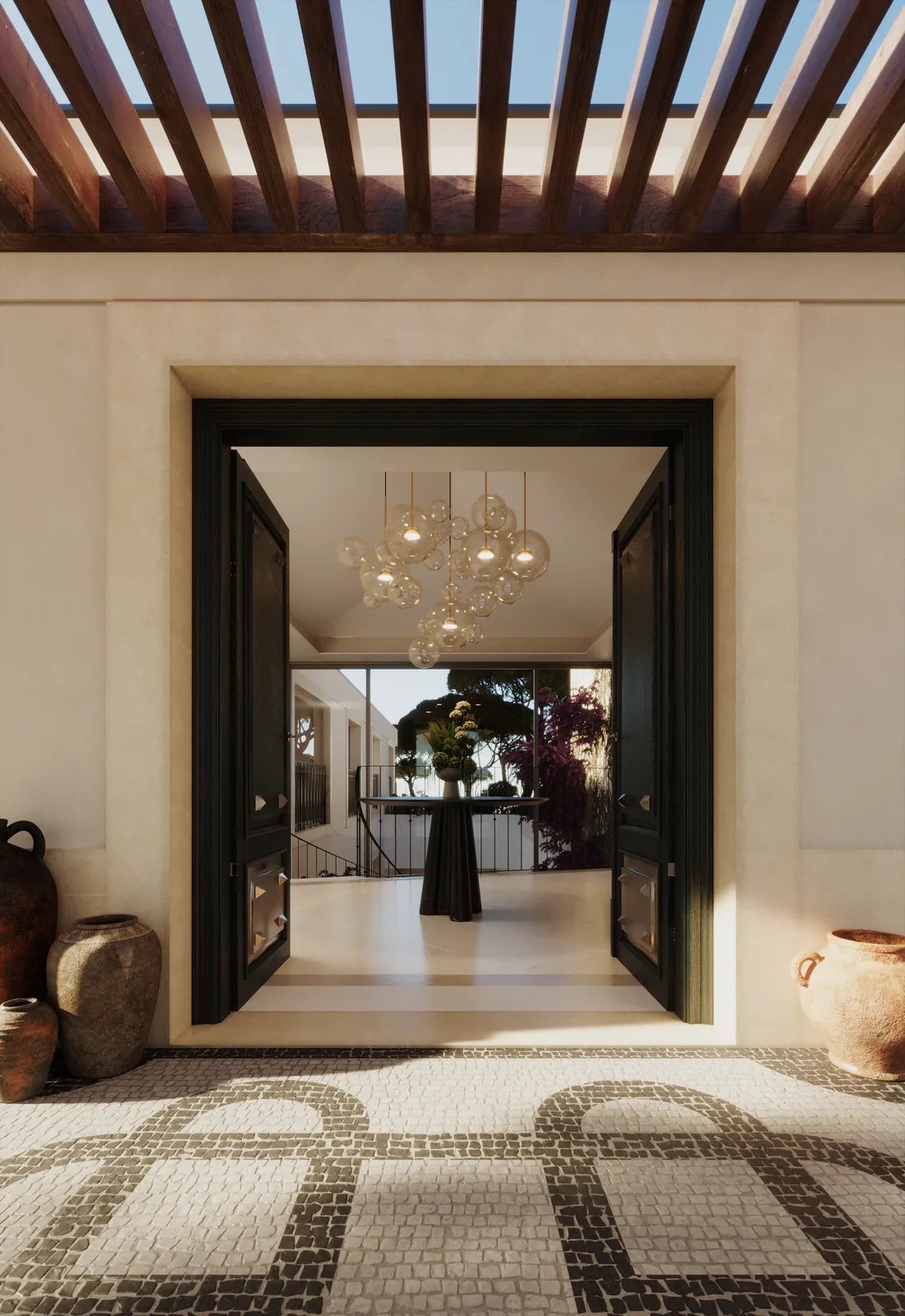 The entrance hall: a black-framed double door standing open under a timber pergola, a pebble mosaic floor in a looping pattern, terracotta jars on either side and a chandelier beyond.